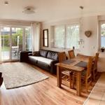 Living and dining area with kitchen, sofa, dining table, and terrace door.