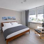Schlafzimmer mit Doppelbett, Sessel und Fenster mit Blick.
