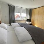 Schlafzimmer mit Doppelbett, Kleiderschrank und Fenster mit Blick.