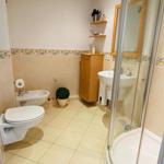 Badezimmer mit Dusche, Waschbecken und Toilette.