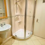 Badezimmer mit Duschkabine, Waschbecken und Spiegel