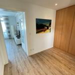 Schlafzimmer mit Holzboden, Kleiderschrank und Wandbild. Durchgang zur Wohnfläche.