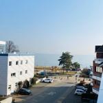 Blick auf Strandhotel und Meer mit Parkplatz und Spielplatz