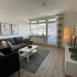 Wohnzimmer mit Sofa, Couchtisch und Balkonansicht.