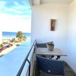 Balkon mit Tisch, Stühlen und Blick aufs Meer.