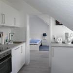 Küche mit Arbeitsfläche und Schlafzimmer im Hintergrund.