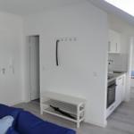 Wohnung mit Küche, Schlafzimmer und blauem Sofa.