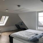 Bedroom with skylight and sea view through large window.