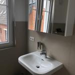 Sink with mirror and window view of buildings