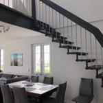 Dining area with table and chairs under a staircase.