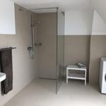 Bathroom with shower, washing machine, and towel rack.