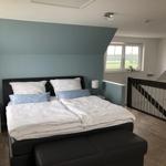 Bedroom with double bed, window, and staircase