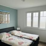 Bedroom with double bed, window, and wall picture.