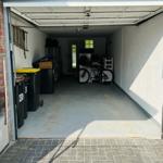 Garage mit Fahrrad, Mülltonnen und Tür im Hintergrund