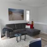 Living room with gray sofa, small table, and wall art