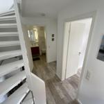 House with stairs, bathroom, and door. Wall picture with stones.