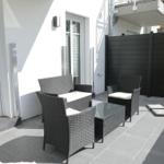 Terrace with seating group, glass table, and yellow umbrella.