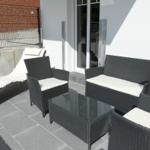 Terrace with garden furniture, bench, chaise lounge, and glass table.