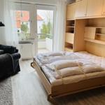 Schlafzimmer mit ausziehbarer Matratze und integriertem Schrank. Fenster mit Blick auf Balkon.