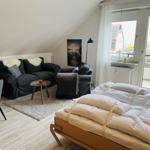 Schlafzimmer mit Bett, Sofa und Balkonansicht.