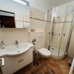 Badezimmer mit Dusche, Waschbecken und Toilette.