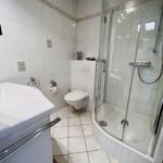 Badezimmer mit Dusche, Toilette und Waschbecken.