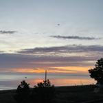 Sonnenuntergang über dem Meer mit Boot und Kite.