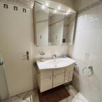 Badezimmer mit Waschbecken, Spiegel und Dusche