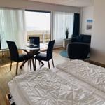 Schlafzimmer mit Blick aufs Meer, Esstisch und Sofa