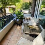 Terrasse mit Sitzgruppe, Pflanzen und Blick auf Garten.