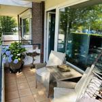 Terrasse mit Sitzgruppe, Pflanzen und Glasfront zur Wohnung.