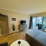 Schlafzimmer mit Bett, TV und Balkonansicht
