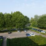 Parkplatz mit Bäumen und gepflasterten Wegen