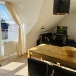 Doppelzimmer mit Balkon, Esstisch und Sofa unter Dachschrägen.