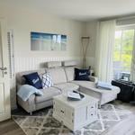 Wohnzimmer mit Sofa, Tisch und Bild an der Wand