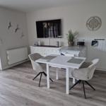 Esszimmer mit Tisch, Stühlen und Fernseher an der Wand