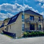 Modern house with balconies and skylights under blue sky.