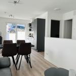 Living and dining area with table, chairs, and kitchenette.