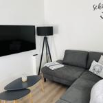 Gray sofa with pillows, wall TV, and floor lamp in living room.