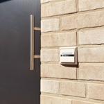 Unit Whg.1 with nameplate on stone wall beside dark door.