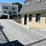 House with stone facade, skylights, and paved driveway.