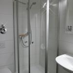 Badezimmer mit Dusche, Waschbecken und Toilette