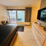 Schlafzimmer mit Bett, TV und Balkonansicht.