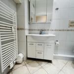 Badezimmer mit Waschbecken, Spiegelschrank, Heizkörper und Toilette.