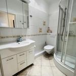 Badezimmer mit Dusche, Waschbecken und WC.