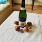 Auf Tisch mit Tischdecke steht Champagner, Eier und Schokolade.