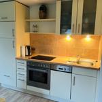 Küche mit Arbeitsplatte, Spüle, Herd und Kühlschrank.