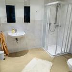 Badezimmer mit Dusche, Waschbecken und Spiegel