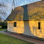 Haus mit Holzfassade, Dach und Terrasse im Garten