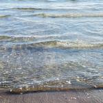 Klareres Wasser rollt sanft an den Strand.